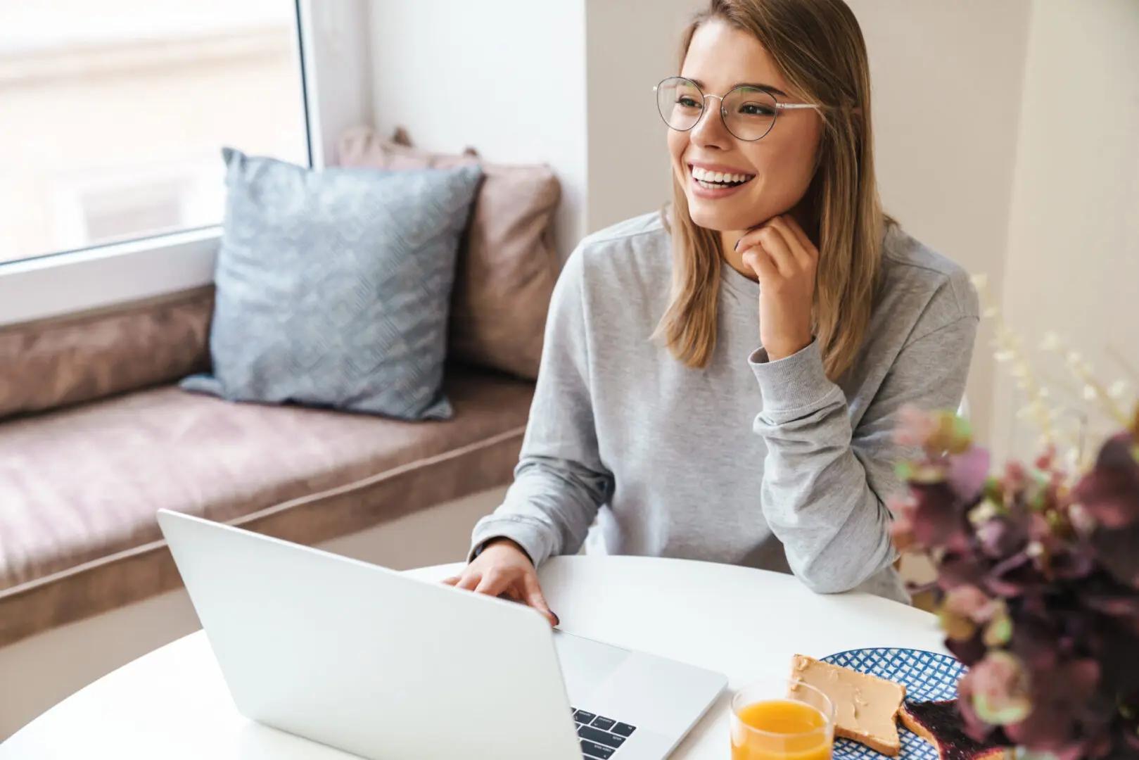 A woman sitting at a table with her laptop.